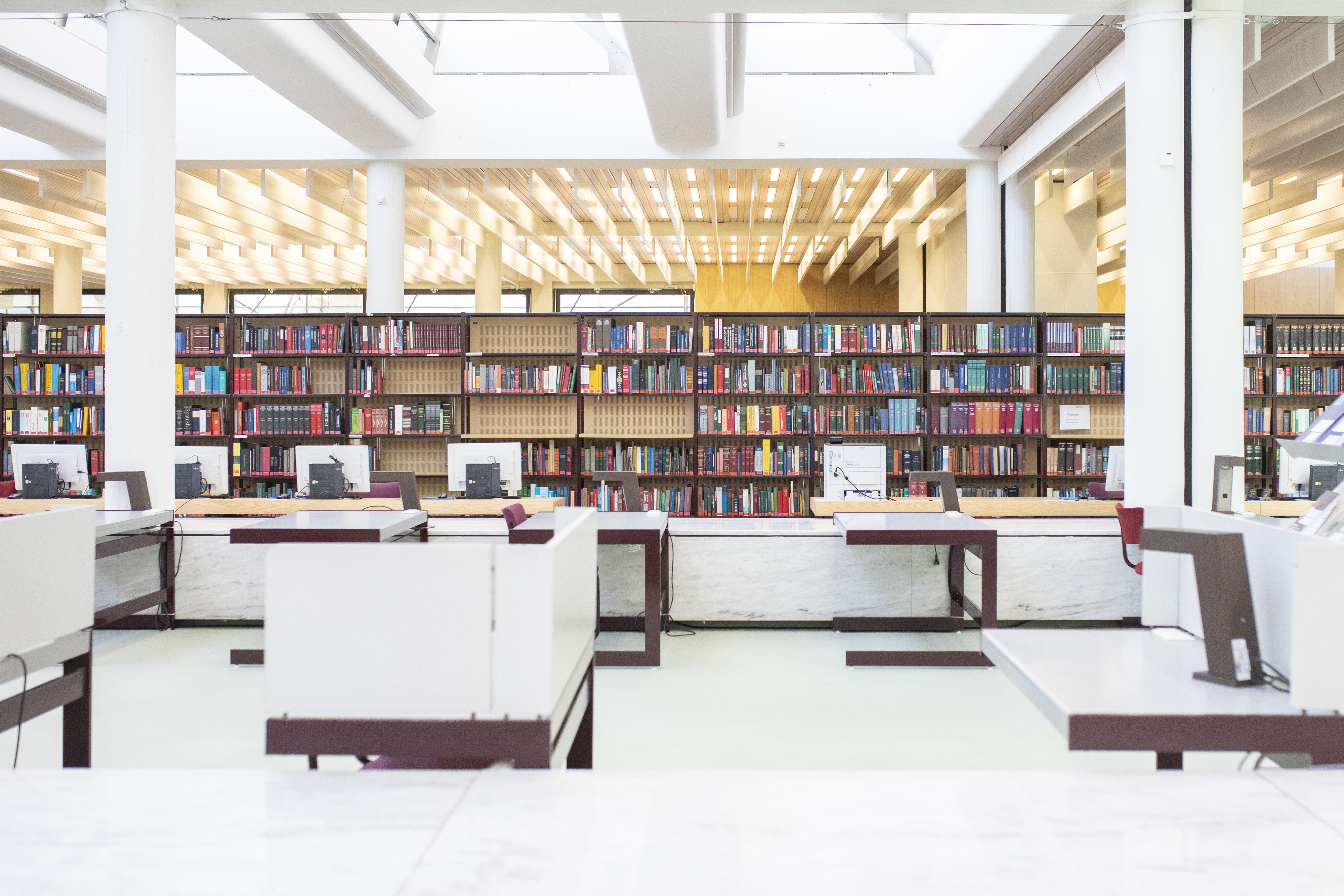 Sala de leitura com estante de livros e estações de trabalho (abre uma ampliação da imagem)