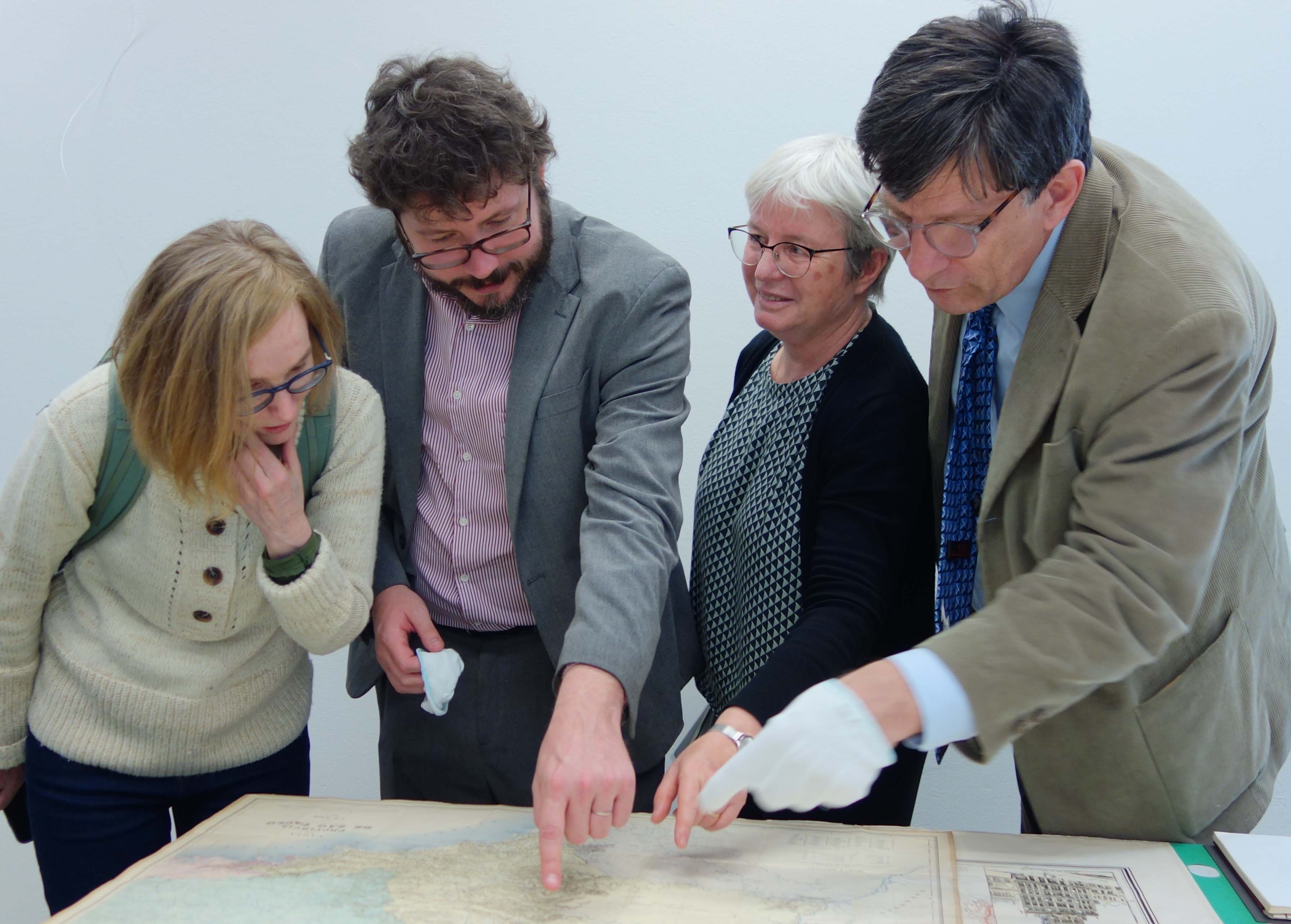 Cuatro personas (entre ellas la directora del IAI) mirando a un mapa del IAI (abre una ampliación de la imagen)