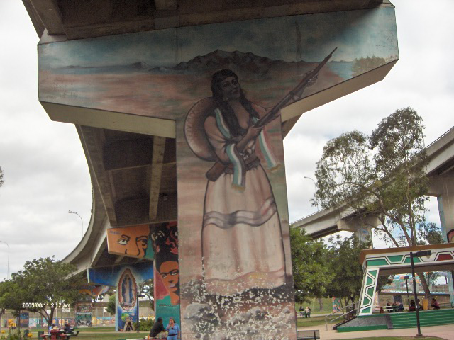 Pintura de una mujer con vestido, sombrero para el sol y rifle sobre un pilar de puente