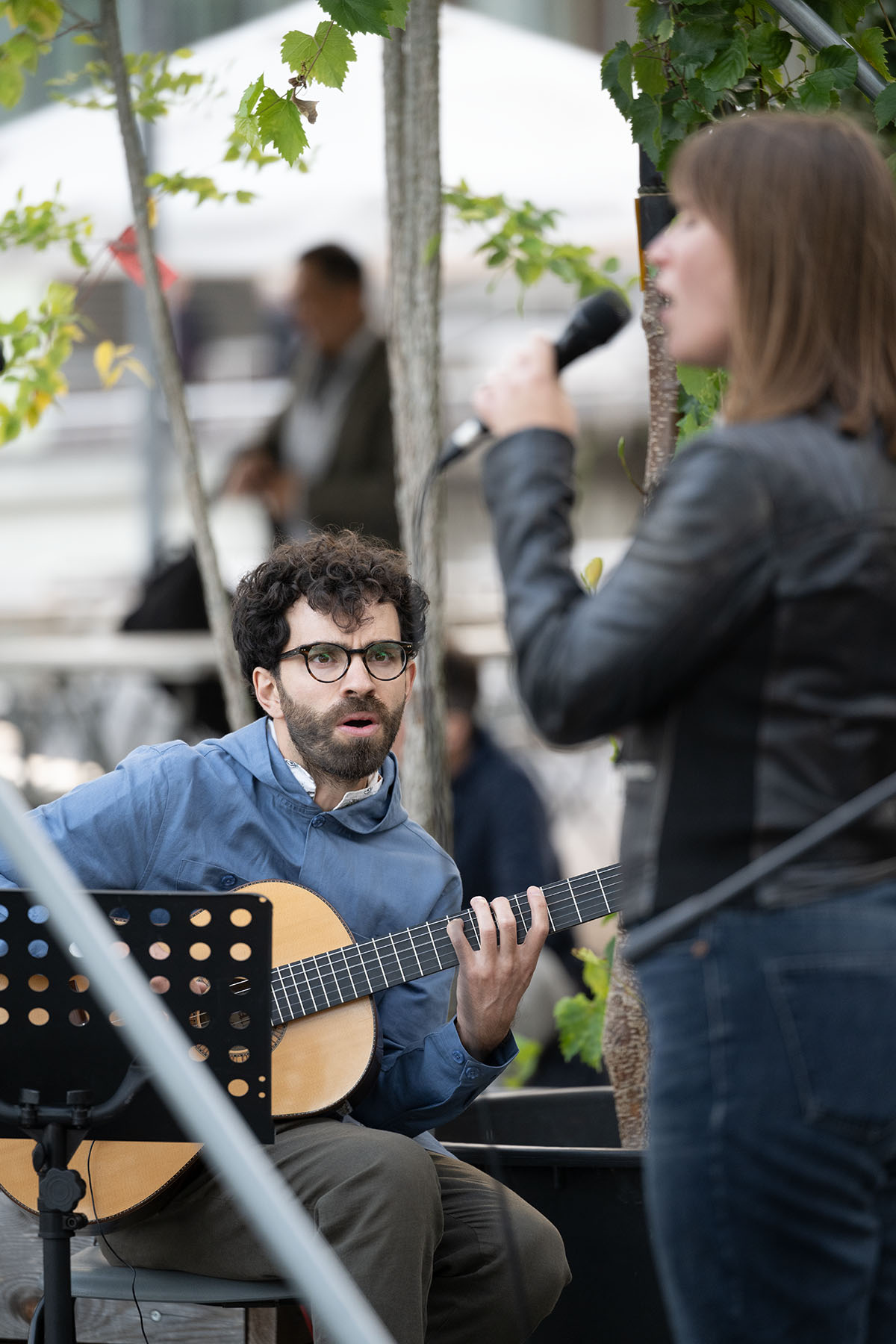 Cantora com guitarrista em um palco ao ar livre