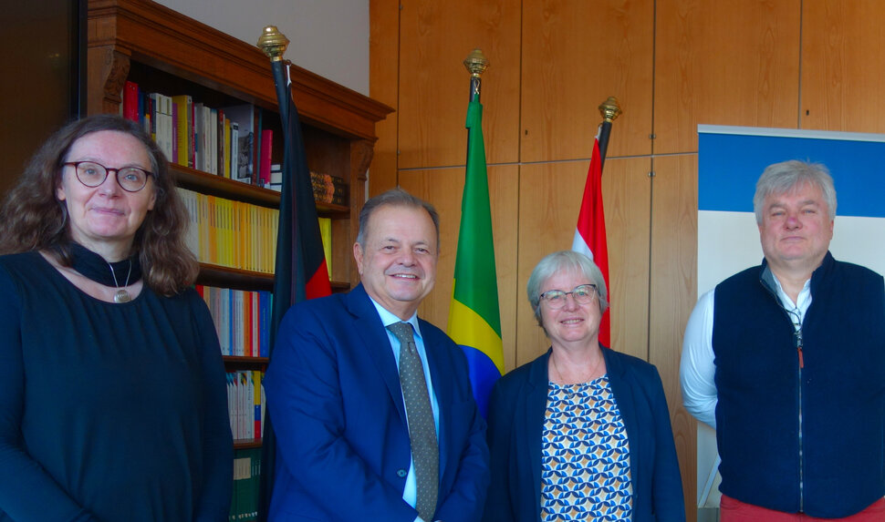 VIer Personen blicken in die Kamera