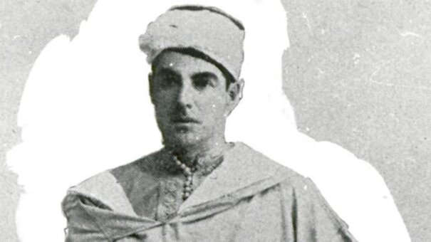 Black-and-white photograph of a man wearing a white head covering