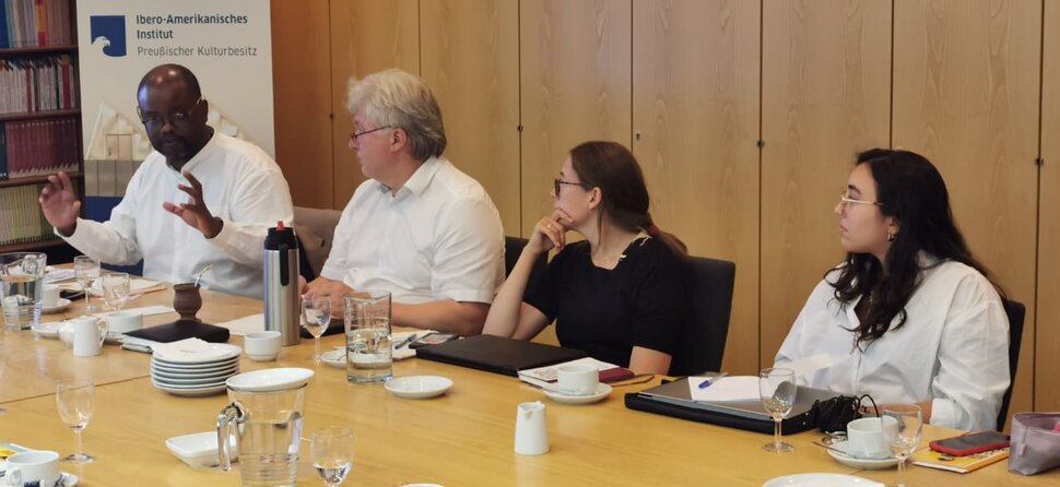 Three people are listening to a speaker