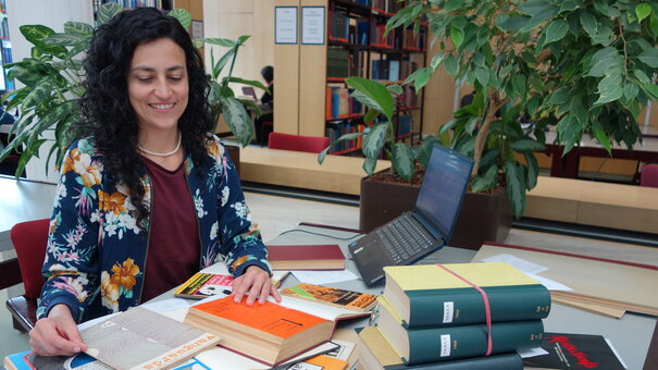 Guest researcher Sandra Restrepo with books at her workstation in the reading room