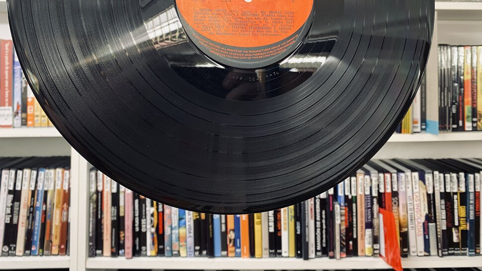 Disco na frente da prateleira com capas de discos