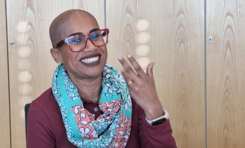 Daiana Nascimento dos Santos hebt während eines Vortrags die Hand und lacht