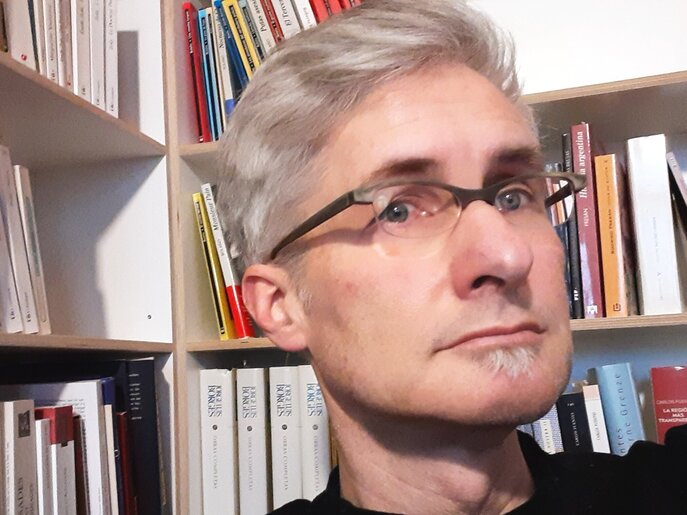 Foto retrato de Jörg Dünne delante de una estantería