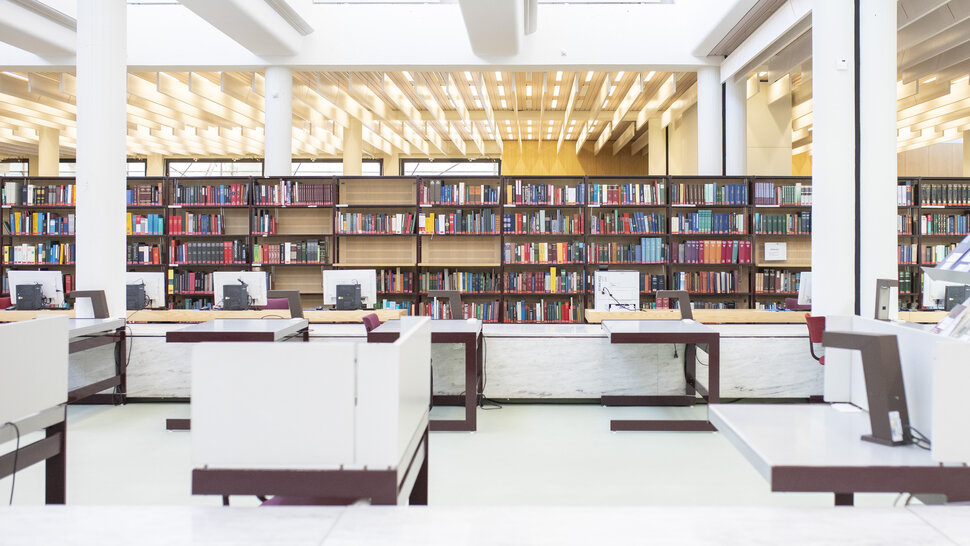 Lesesaal mit Bücherregal und Arbeitsplätzen