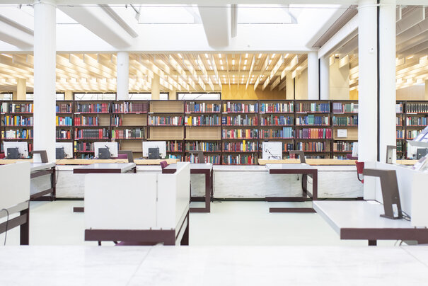 Lesesaal mit Bücherregal und Arbeitsplätzen