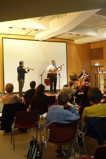 El violinista, el guitarrista y la violonchelista tocan en un escenario (abre una ampliación de la imagen)