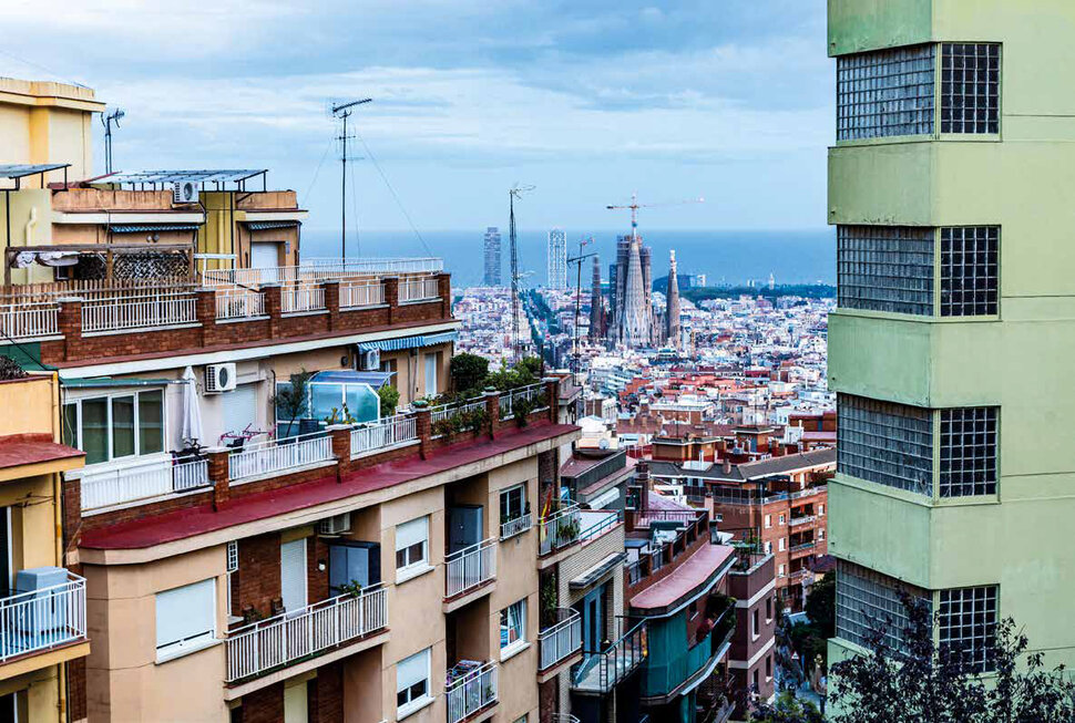 Blick auf ein modernes Wohngebäude links, im Hintergrund Skyline von Barcelona (öffnet Vergrößerung des Bildes)