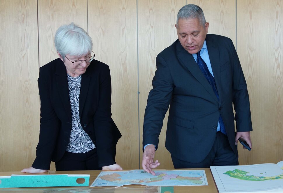 Dos personas mirando materiales de biblioteca sobre una mesa