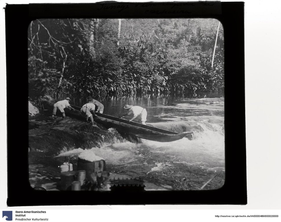 Historische Fotografie, vier Personen heben ein Kanu über eine kleine Stromschnelle