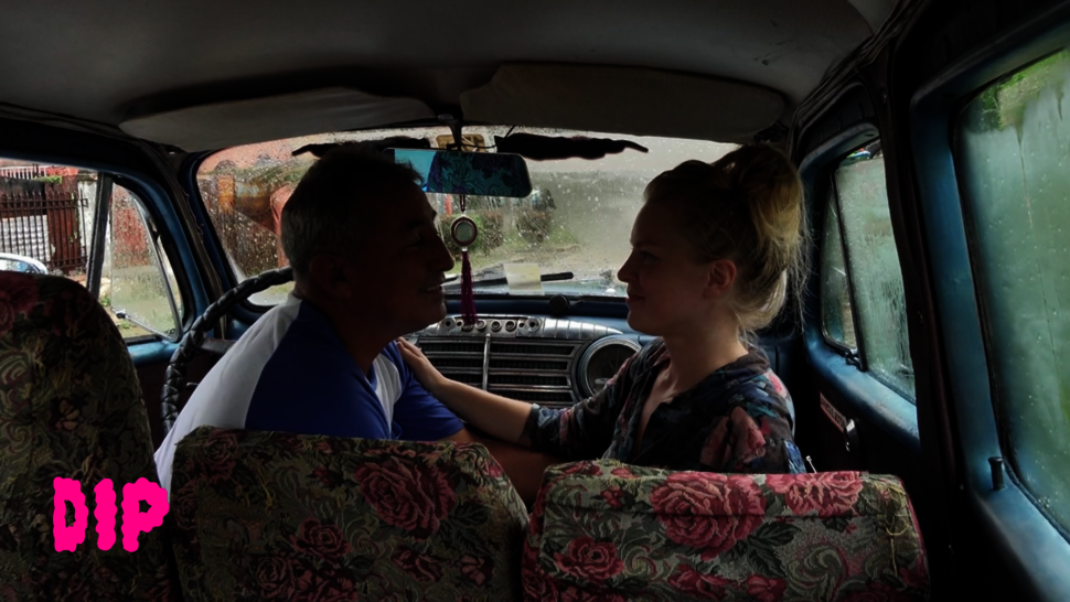 A taxi driver and a female passenger are holding each other by the arms