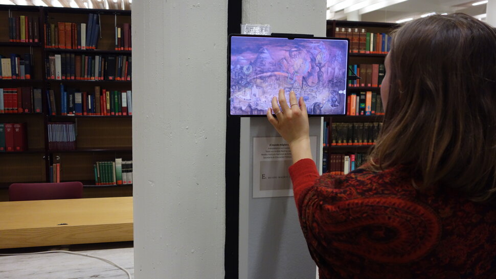 Mulher olhando para uma pintura em um tablet na exposição (abre uma ampliação da imagem)